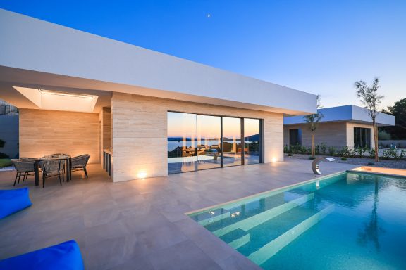 Moderner Wohnbereich mit Pool, entspannendem Ambiente und Aussicht bei Sonnenuntergang.