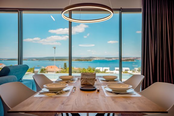 Modern Essbereich mit Blick auf einen blauen See und klare Himmel.