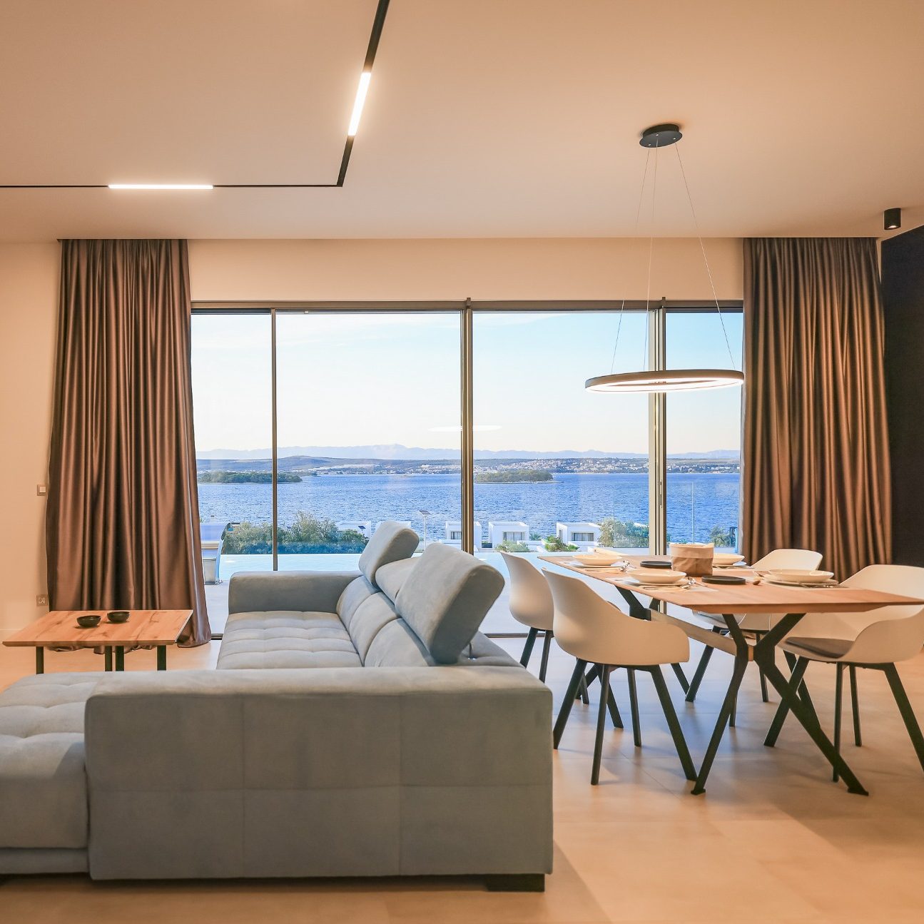 Offener Wohnbereich der Villa View mit großen Panoramafenstern und Meerblick